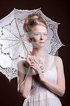 Woman in vintage dress holding a lace umbrella
