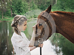 Woman in vintage dress touching to horse face