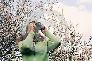 Woman with vintage retro camera walking in the park