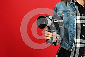 Woman with vintage video camera on background, closeup. Space for text