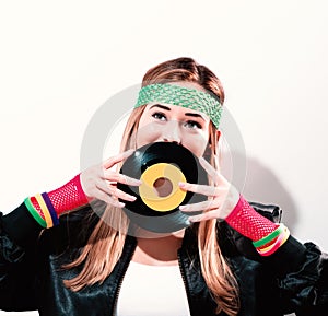 Woman with a vinyl record in 1980`s fashion