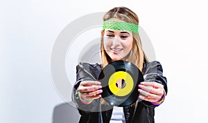 Woman with a vinyl record in 1980`s fashion