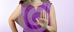 A woman in a violet dress made a stop gesture. Stop Domestic Violence Concept