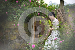 Woman and violin in rose garden