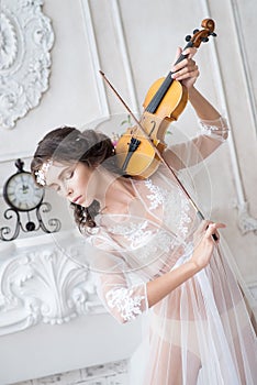 Woman with violin in white peignoir. Boudoir. seductive