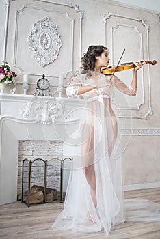 Woman with violin in white peignoir. Boudoir. seductive