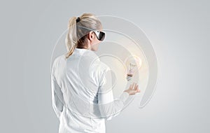 Woman in virtual reality glasses looking to the hologram, isolated.