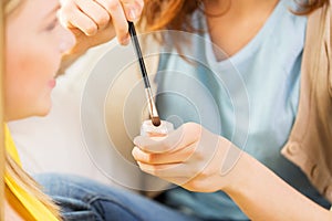 Woman visagist applying eyeshade by makeup brush
