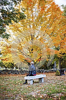 Woman visiting grave in cemetery