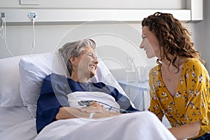 Woman visiting senior mother in hospital