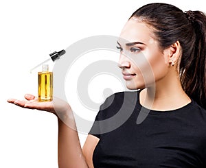 Woman with vitiligo presenting cosmetic primer oil for beauty.