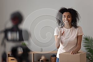 Woman vlogger recording new vlog opening carton box with goods