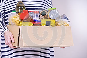 Woman volunteer hands holding food donations box with food grocery products