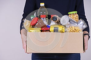 Woman volunteer hands holding food donations box with food grocery products