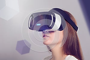 Woman in VR headset looking up at the objects in virtual reality