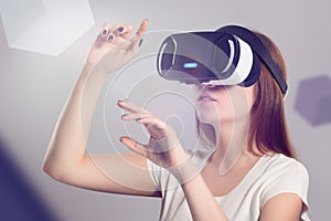 Woman in VR headset looking up and trying to touch objects