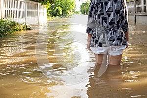 Woman wade flooding in her house. Closeup on her leg. View behin