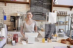 Woman waiting behind the counter at a coffee shop, close up