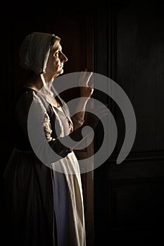 Woman waiting at the door in darkness