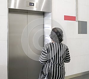 Woman waiting for elevator inside a building