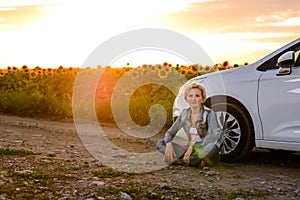 Woman waiting beside her car on a rural road