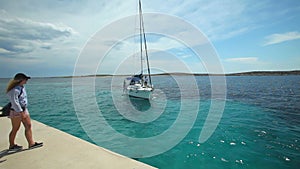 Woman waiting for sailing boat on dock