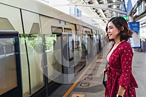 Woman waiting sky train at station in Bangkok, Thailand