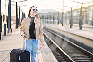 Woman waiting for train at station. Happy smiling lady.