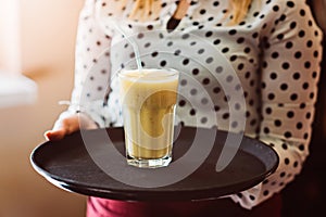 Woman waitress holding fresh delicious pineapple cocktail