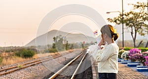 Woman waits train on railway platform.Thailand