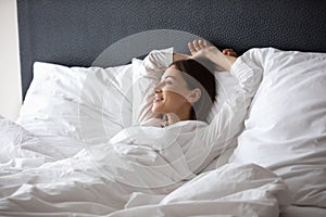 Woman wake up lying in bed dreaming enjoy new day