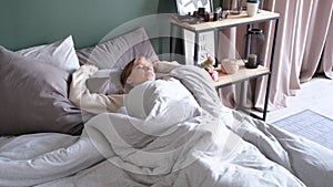 Woman waking up at bed at home