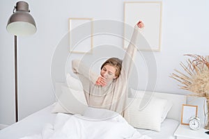 Woman waking up at bed at home