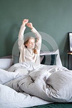 Woman waking up at bed at home