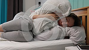 Woman Waking Up in a Cozy Bedroom to Early Morning Alarm