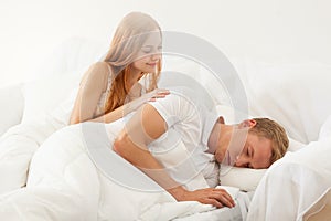 Woman waking up a man in the morning