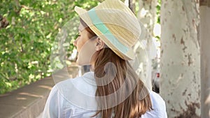 Woman walk along waterfront in slow motion. Behind view of female traveler enjoying vacation outdoor