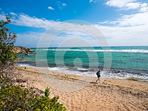 A woman walk on the beautiful deserted beach of Guanica Reserve in Puerto Rico photo