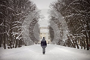 Woman walk on forest path with palace in the front