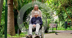Woman on a walk with her senior father in wheelchair in nature in green garden in Australia. Happy, exercise and elderly