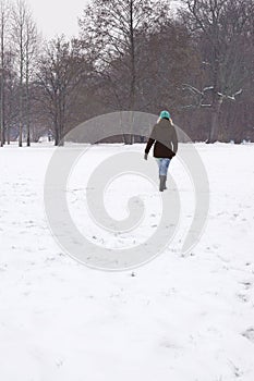 Woman walking across snow covered field