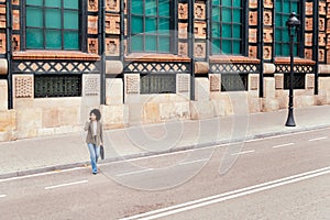 woman walking across the street talking by phone