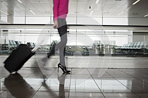 Woman walking in airport, blurred in motion