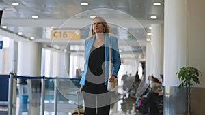 Woman walking in airport terminal.