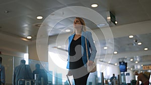 Woman walking in airport terminal.