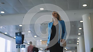 Woman walking in airport terminal.