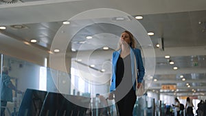 Woman walking in airport terminal.