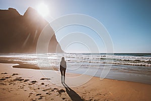 Woman walking alone on Kvalvika beach in Norway enjoying ocean view