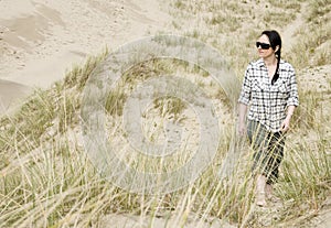 Woman walking alone in sand dunes