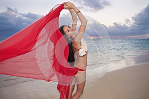 Woman walking along a beach at sunrise